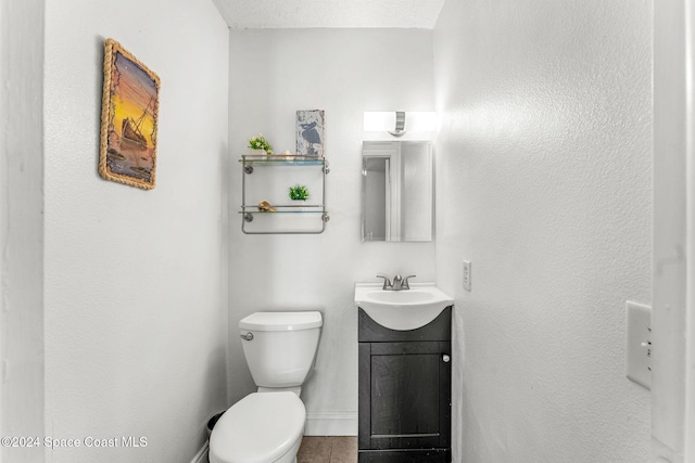 bathroom with toilet, vanity, and a textured ceiling