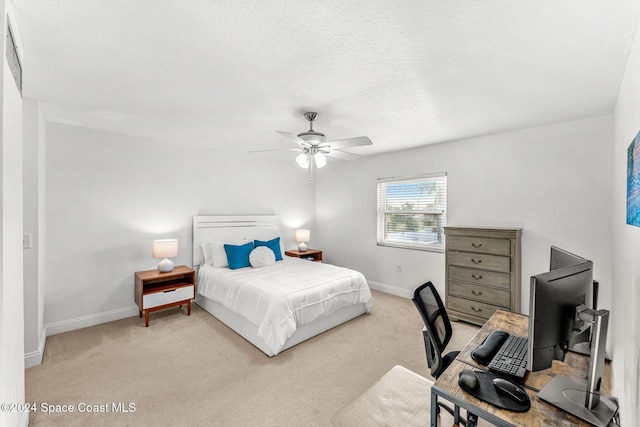 carpeted bedroom with ceiling fan and a textured ceiling