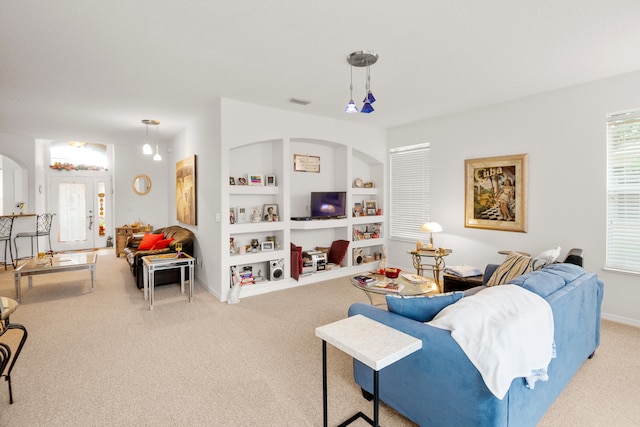 carpeted living room featuring built in shelves