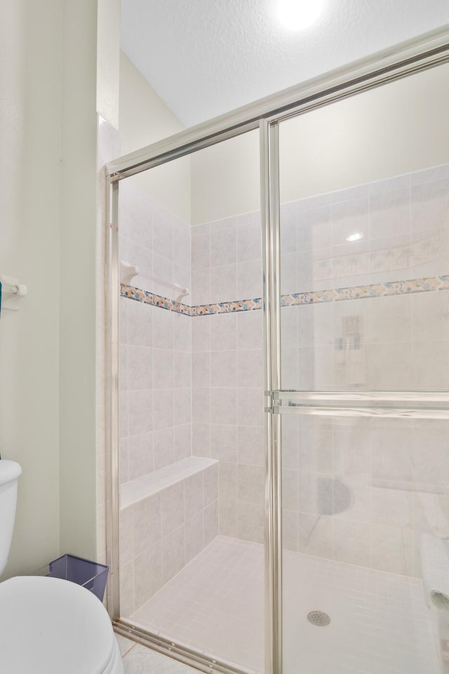 bathroom with an enclosed shower and toilet