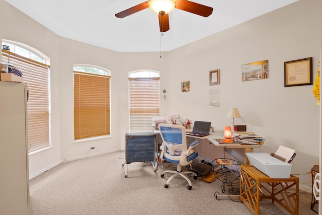 carpeted home office featuring ceiling fan