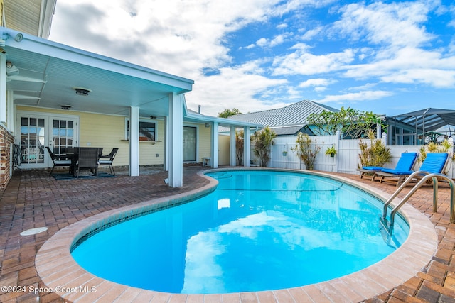 view of pool featuring a patio, ceiling fan, and glass enclosure