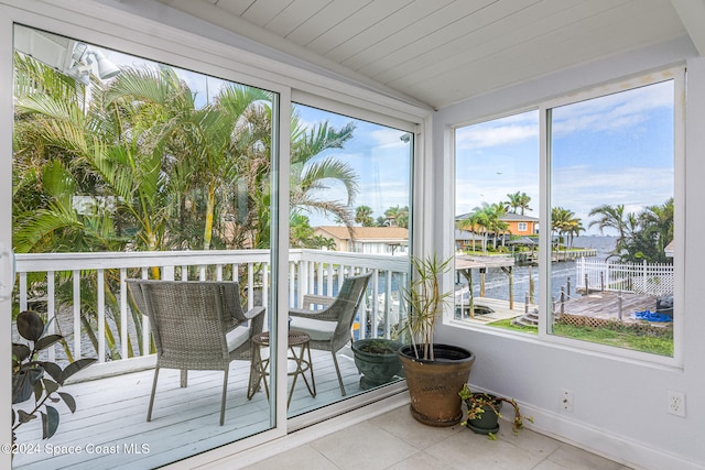 sunroom with a water view and lofted ceiling