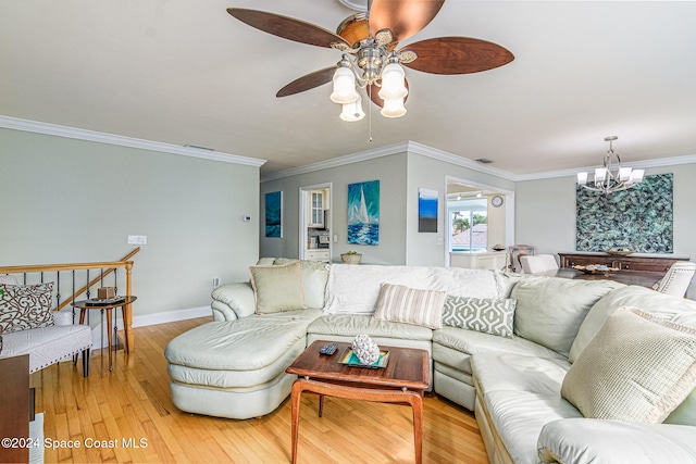 living room with ornamental molding, ceiling fan with notable chandelier, and light hardwood / wood-style flooring