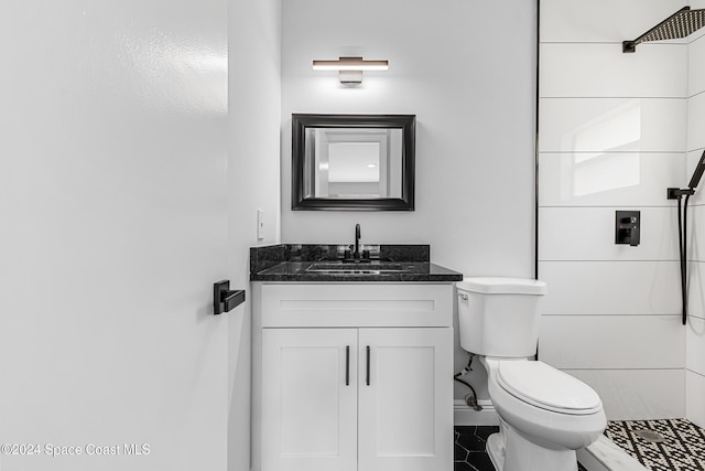 bathroom featuring walk in shower, vanity, tile patterned floors, and toilet