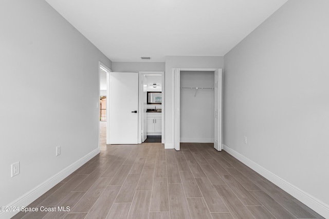 unfurnished bedroom featuring light hardwood / wood-style floors and a closet