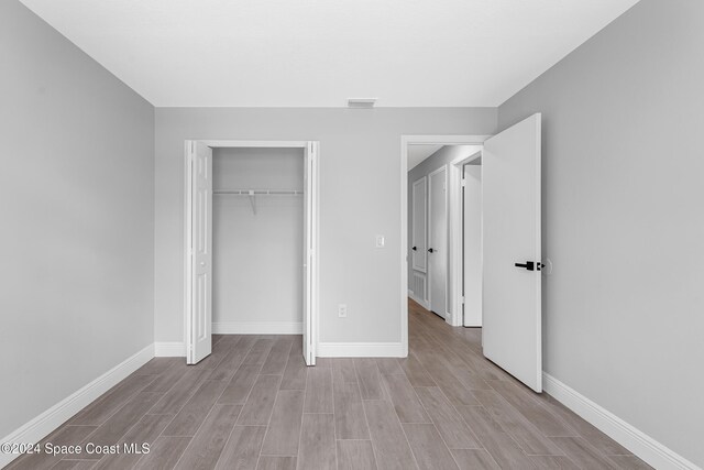 unfurnished bedroom featuring a closet and light wood-type flooring