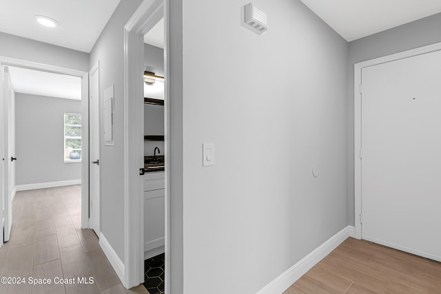 hallway featuring light hardwood / wood-style floors and sink