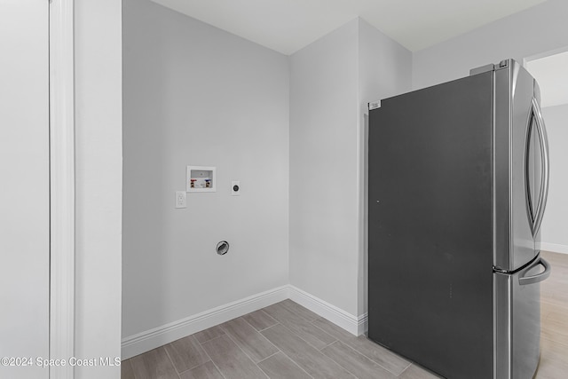 laundry area with hookup for a washing machine, light hardwood / wood-style flooring, and electric dryer hookup