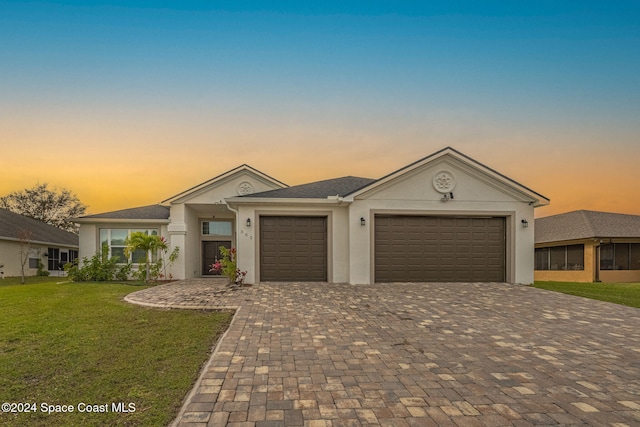 view of front of property featuring a garage and a yard