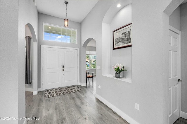 foyer featuring a towering ceiling and light wood-type flooring