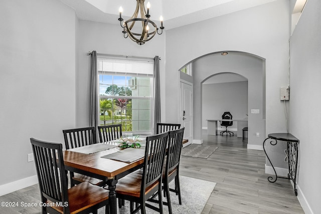 dining room with light wood-type flooring and an inviting chandelier