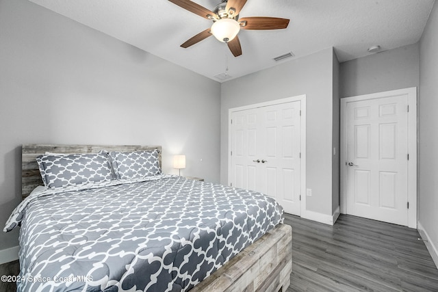 bedroom with ceiling fan, dark hardwood / wood-style floors, a closet, and a textured ceiling