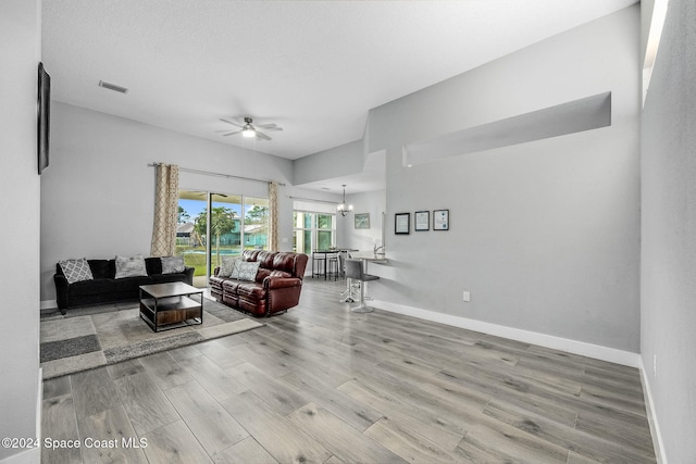 living room featuring hardwood / wood-style floors, ceiling fan, and a textured ceiling