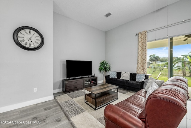 living room featuring light hardwood / wood-style flooring and a textured ceiling