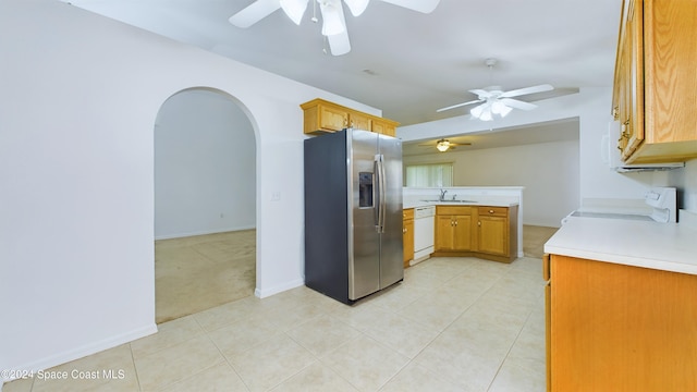 kitchen featuring white dishwasher, kitchen peninsula, range, sink, and stainless steel fridge