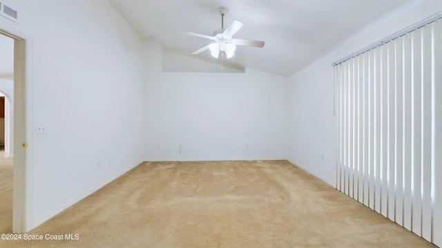 spare room featuring ceiling fan, light colored carpet, and lofted ceiling