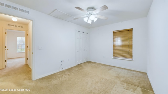 empty room with light carpet and ceiling fan