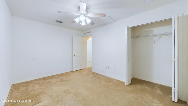 unfurnished bedroom with a closet, light colored carpet, and ceiling fan