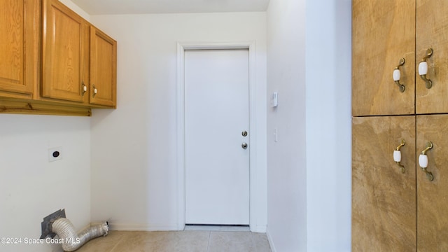 clothes washing area featuring cabinets, light tile patterned flooring, and electric dryer hookup