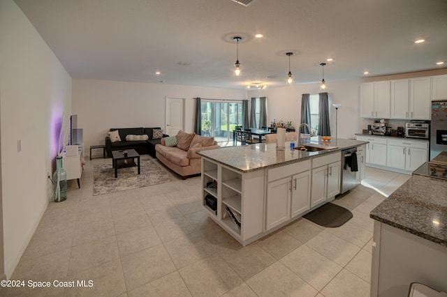 kitchen featuring pendant lighting, sink, dark stone countertops, a kitchen island with sink, and stainless steel appliances