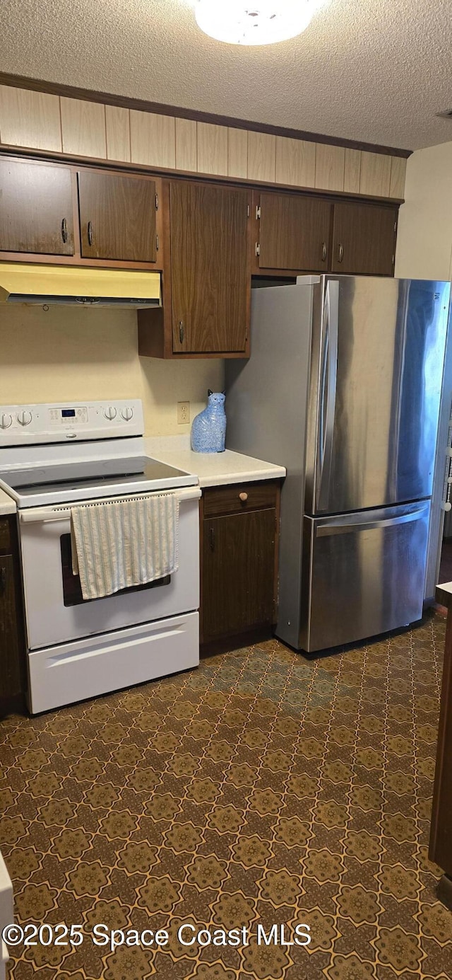 kitchen with a textured ceiling, dark brown cabinets, stainless steel fridge, and white range with electric cooktop