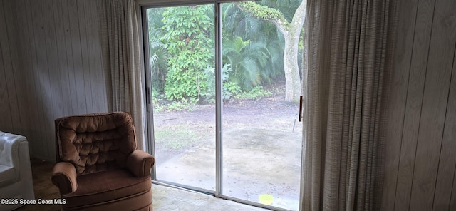 doorway to outside with wood walls