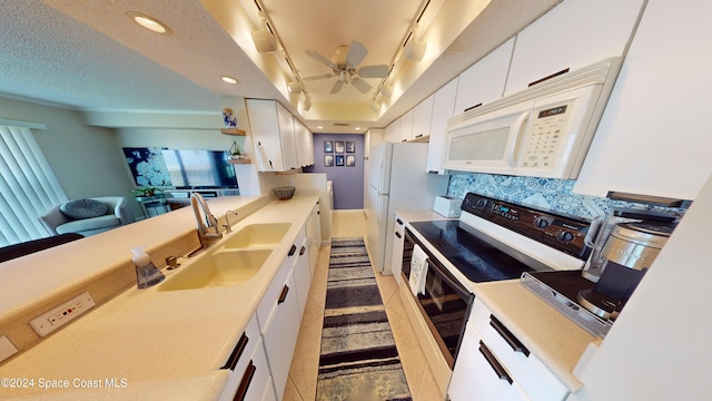 kitchen featuring white cabinetry, sink, a textured ceiling, rail lighting, and white appliances