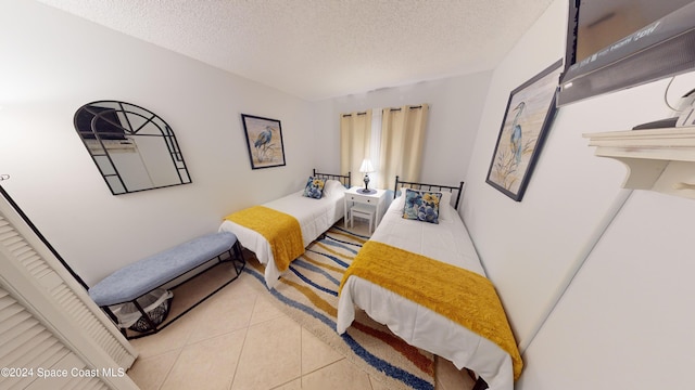 bedroom with a textured ceiling and light tile patterned flooring