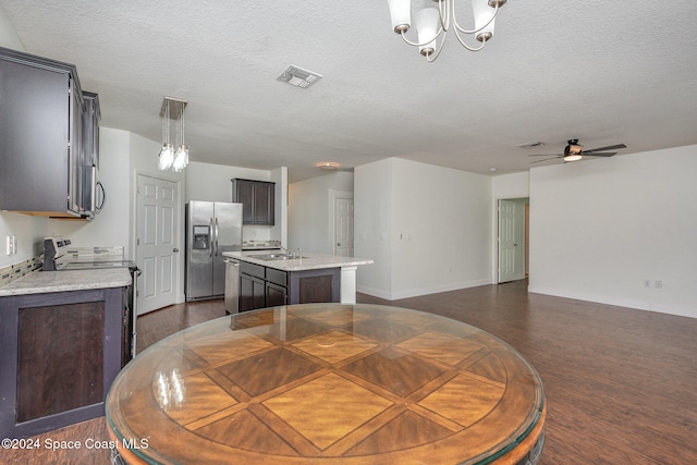 dining room with dark hardwood / wood-style floors, a textured ceiling, sink, and ceiling fan with notable chandelier