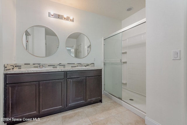 bathroom with vanity, a shower with door, and tile patterned flooring