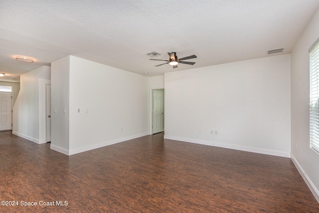 spare room with a textured ceiling, dark wood-type flooring, and ceiling fan