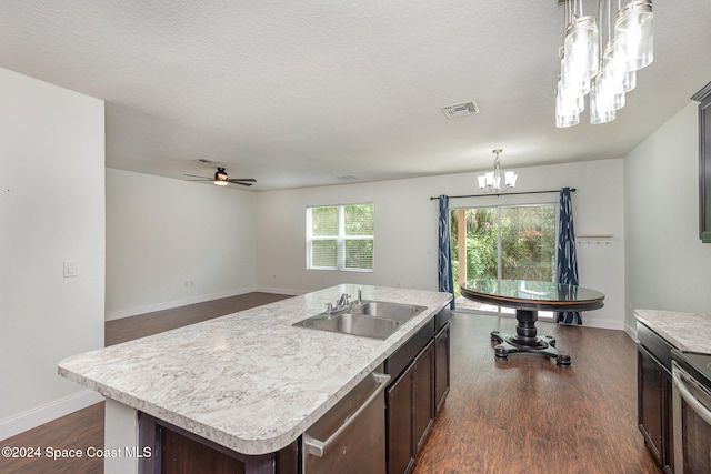 kitchen featuring dark wood-type flooring, pendant lighting, sink, and a kitchen island with sink