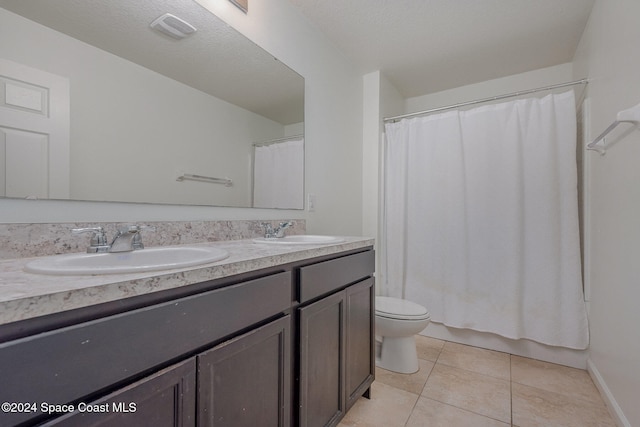 full bathroom featuring shower / bath combo with shower curtain, toilet, tile patterned flooring, a textured ceiling, and vanity