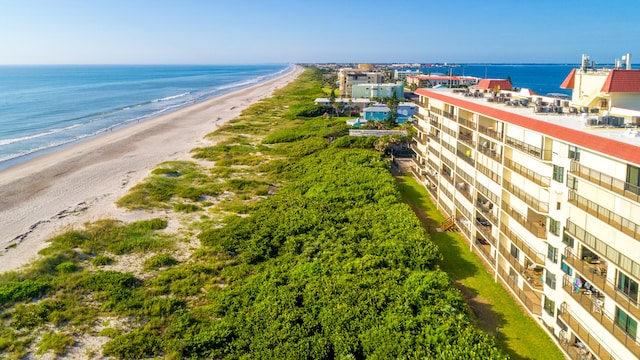 birds eye view of property featuring a water view and a beach view