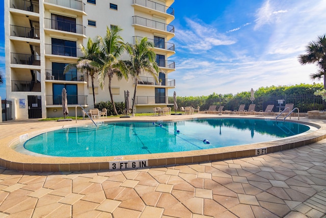 community pool featuring a patio and fence