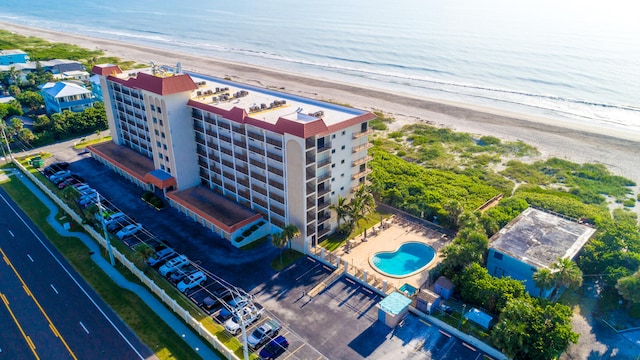 drone / aerial view featuring a beach view and a water view