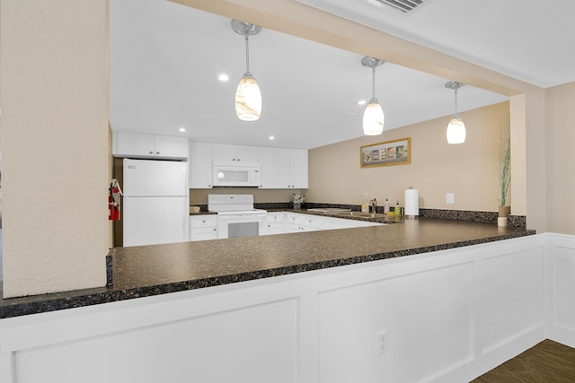 kitchen with white appliances, white cabinetry, and a peninsula