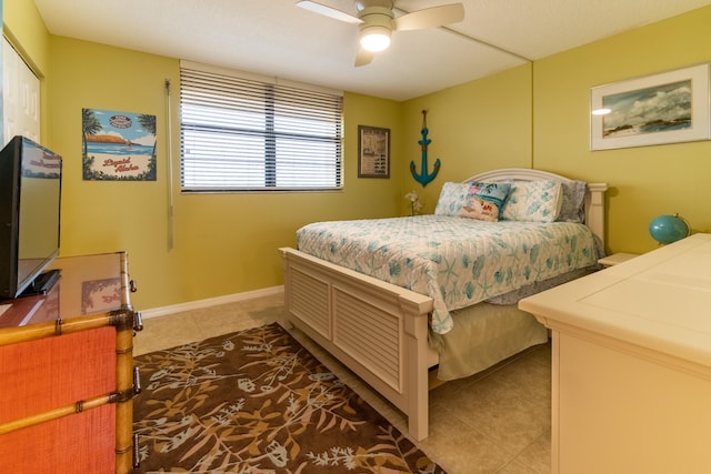 tiled bedroom with a closet, ceiling fan, and baseboards