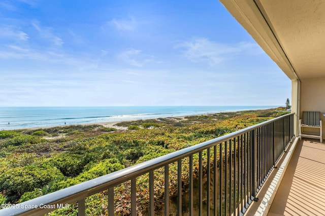 balcony featuring a view of the beach and a water view