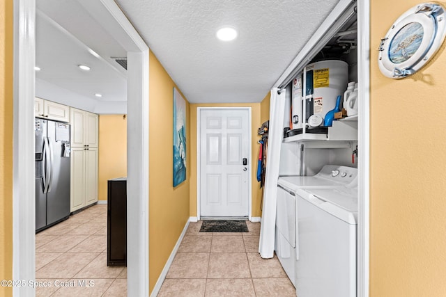 laundry room with light tile patterned flooring, laundry area, a textured ceiling, and separate washer and dryer