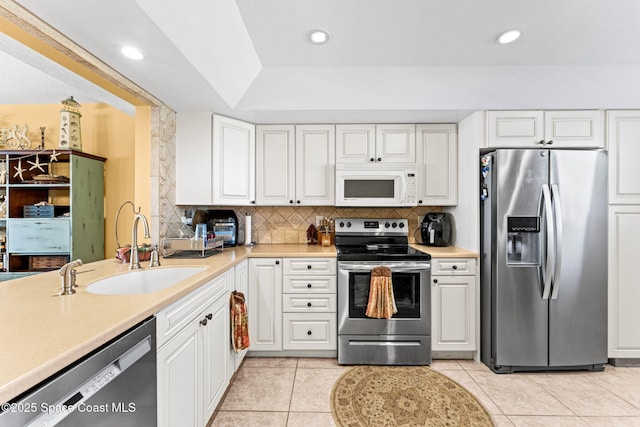 kitchen featuring a sink, tasteful backsplash, appliances with stainless steel finishes, and light countertops