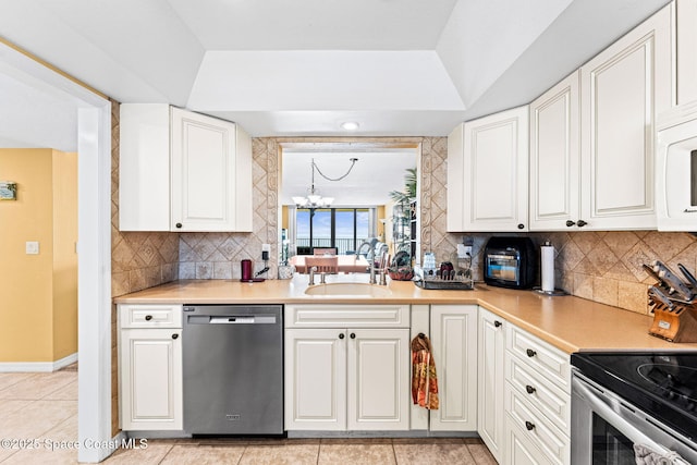 kitchen with a chandelier, white cabinetry, stainless steel appliances, and a sink