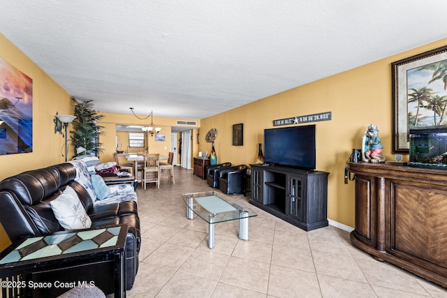 living area featuring a notable chandelier, light tile patterned floors, visible vents, and a textured ceiling