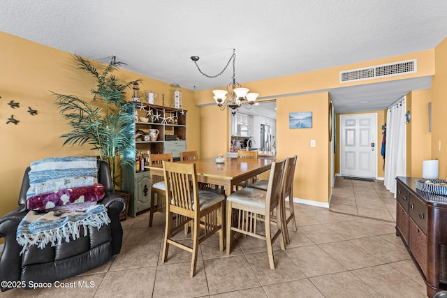 dining space featuring visible vents, baseboards, a chandelier, and light tile patterned flooring