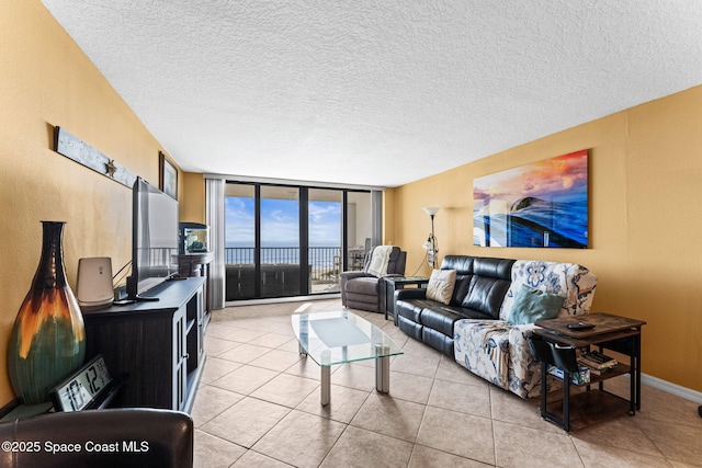 living room featuring floor to ceiling windows, light tile patterned floors, baseboards, and a textured ceiling