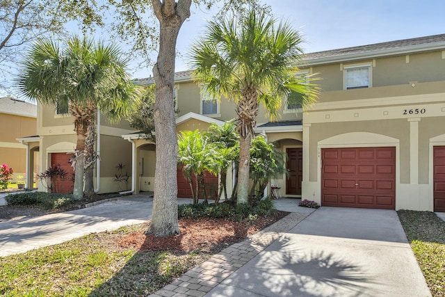 2650 Revolution St Unit 104, Melbourne, FL 32935 - townhome / multi-family property with stucco siding, driveway, and a garage