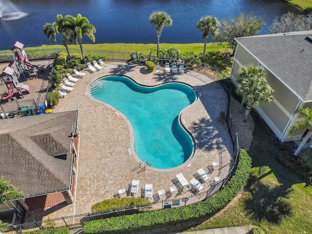 view of swimming pool with a patio area, a water view, and a lawn