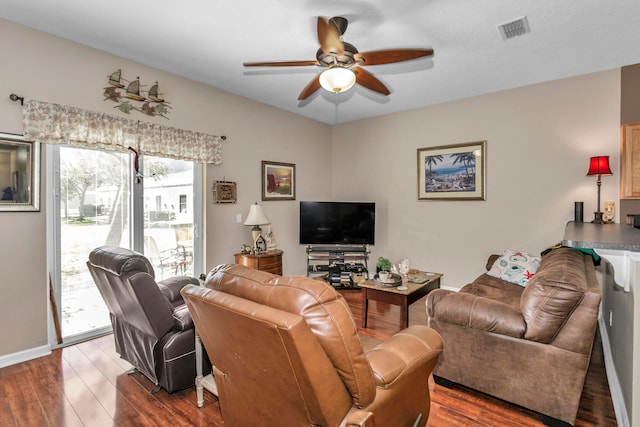 living room featuring ceiling fan and dark hardwood / wood-style floors