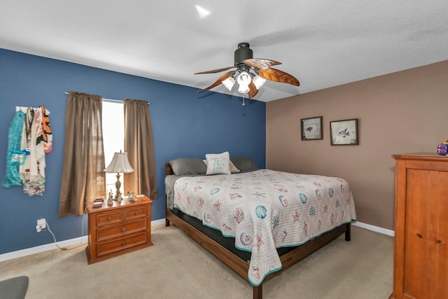 bedroom featuring a textured ceiling, light carpet, and ceiling fan